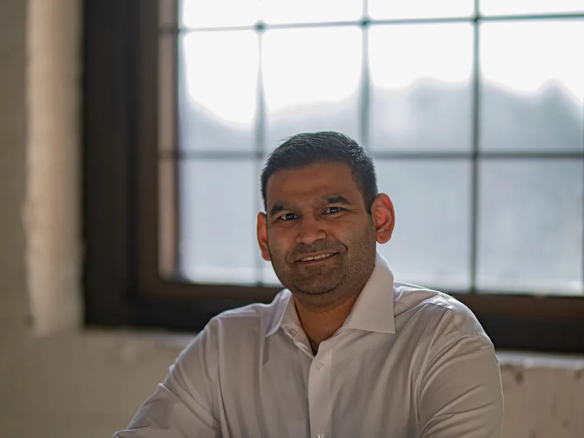 Adarsh Ghosh reviewing financials in his office at dusk
